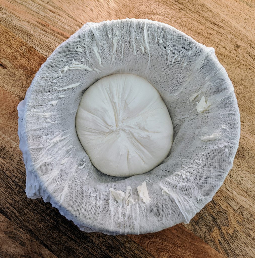 Labneh in cheesecloth after straining