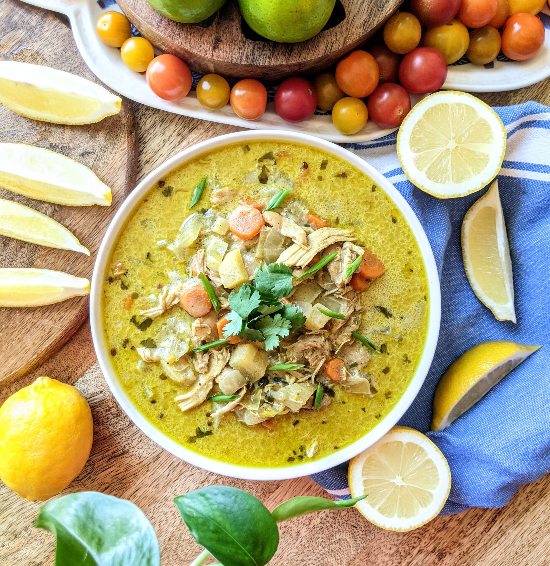 A bowl of vibrant lemon and curry soup, loaded with shredded chicken, apples, carrots, celery, and basmati rice.
