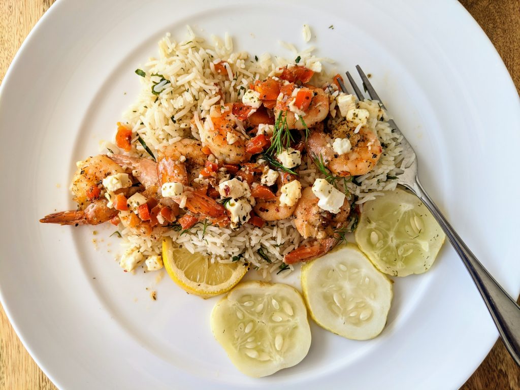 Mediterranean Style Shrimp with feta and fresh herbs, served over lemon and herb rice and pickled lemon cucumbers.