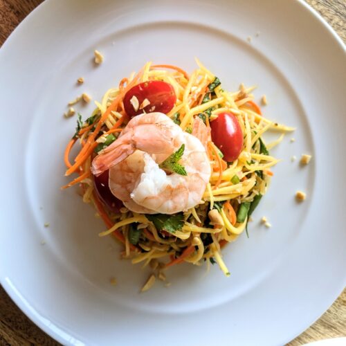 Colorful and crunchy papaya salad, with bruised tomatoes and long beans. Garnished with crushed peanuts and chilled poached shrimp.
