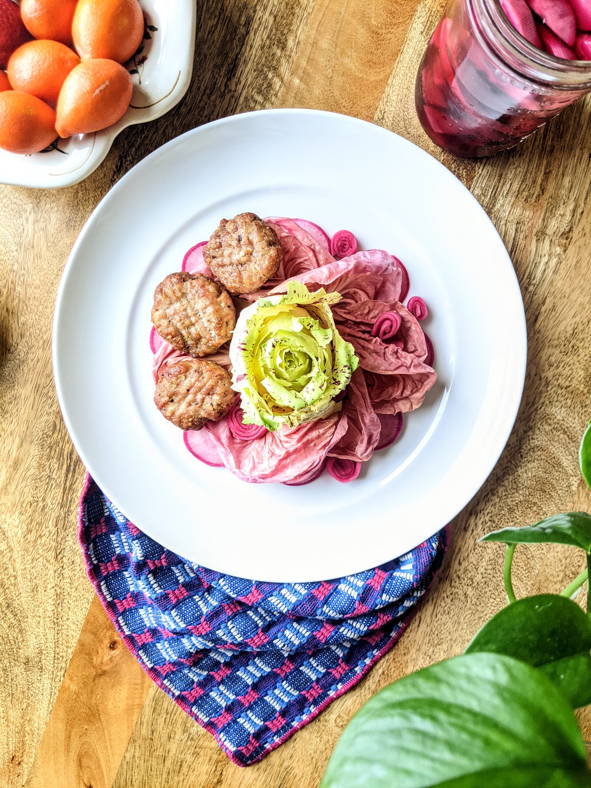 A trio of Pork Lemongrass Patties with Pink Radicchio Salad and Pickled Turnip Roses