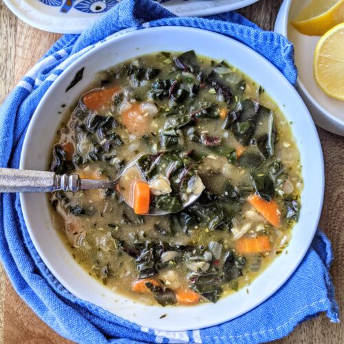 A bowl of rich homemade chicken broth, packed with loads of Swiss chard, carrots, and butter beans.