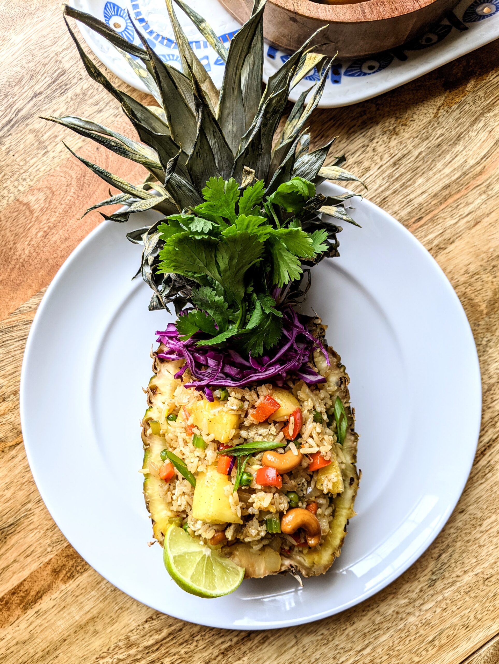 Authentic Thai-style pineapple fried rice served in a hollowed out pineapple. Topped with toasted cashews, fresh cilantro, and raw purple cabbage.