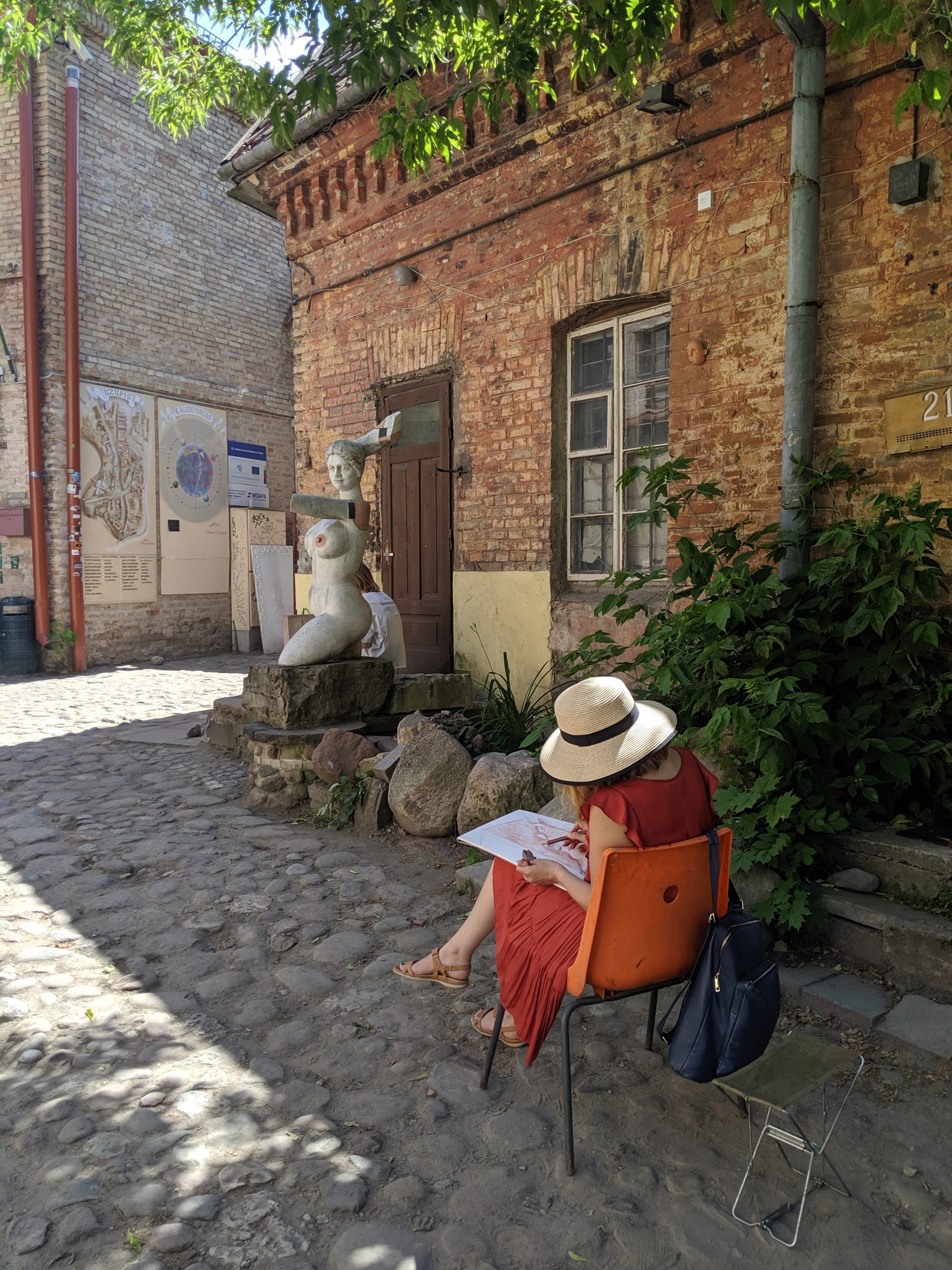 An artist sitting on a chair and drawing in Vilnius Lithuania.