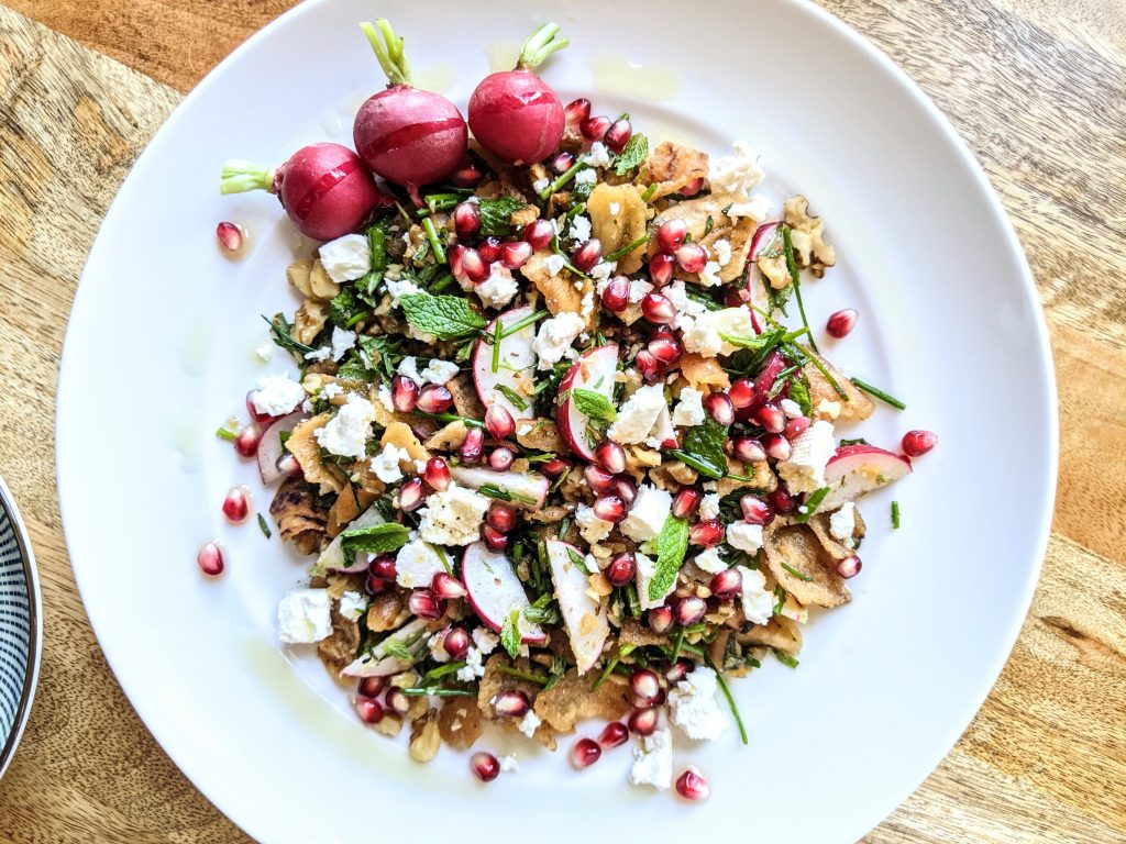 A colorful salad of fragrant mixed herbs, pomegranate, radishes, and feta cheese.