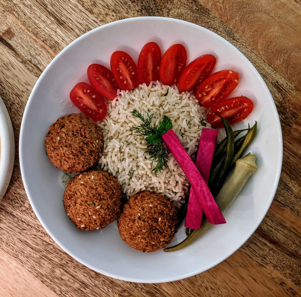 Falafel Platter with rice, quartered small tomatoes, homemade pickled vegetables, and fresh dill.