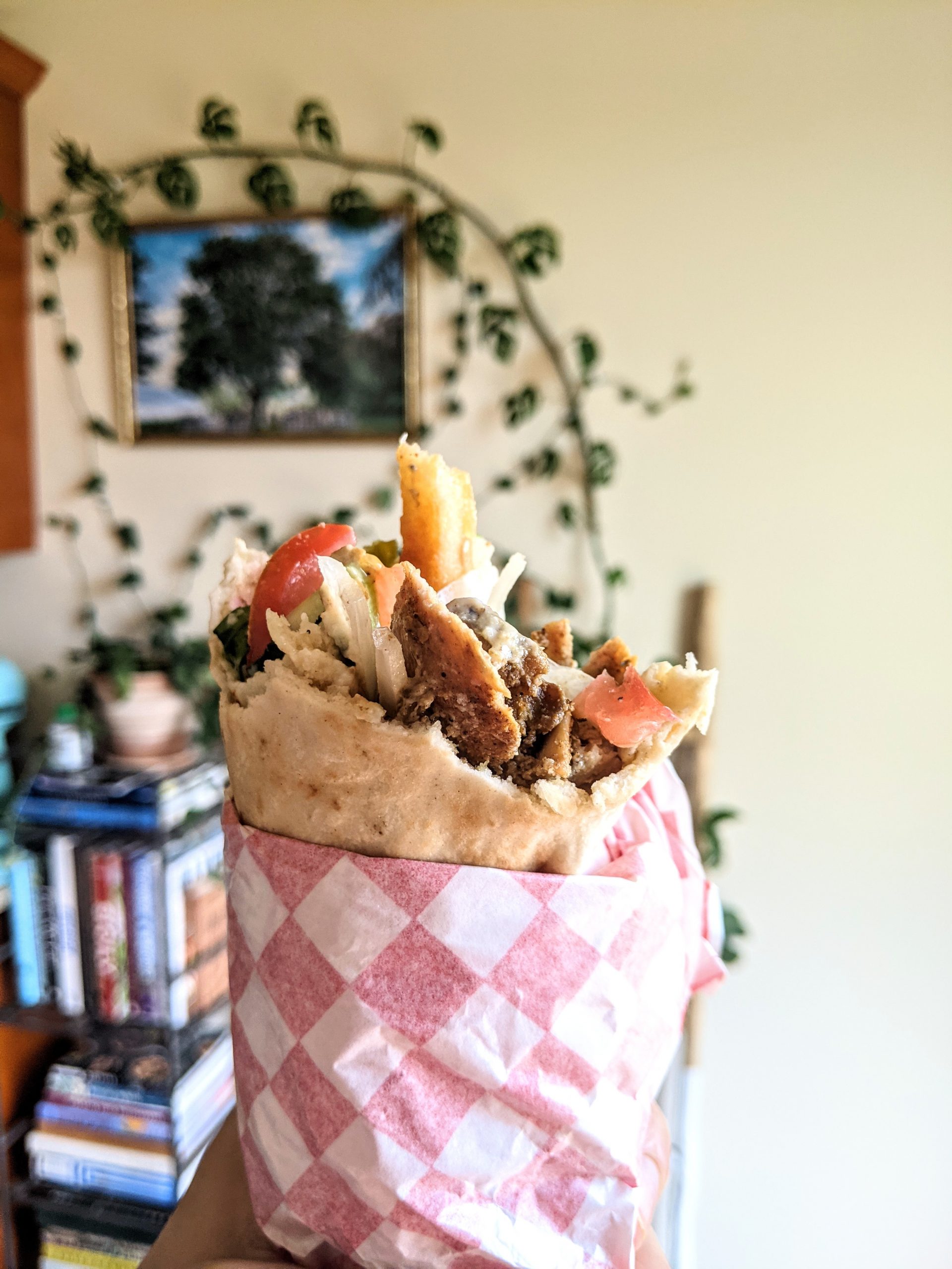 A homemade chicken shawarma wrap with a French fry poking out.