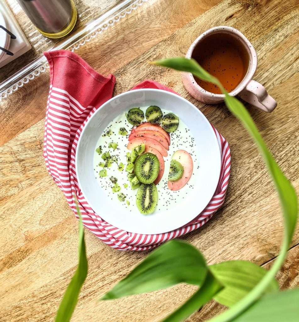 A breakfast bowl with lime yogurt, kiwi, apple, and chia seeds.