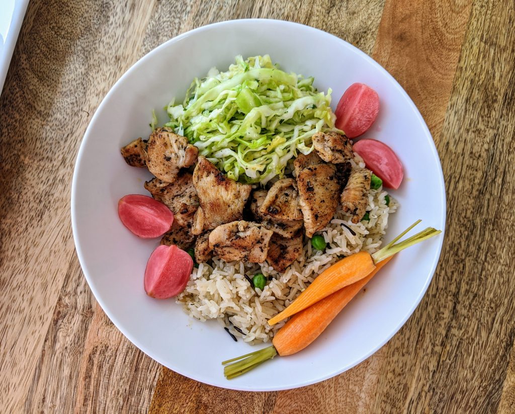Gyro chicken bowl with Salatet Malfouf, rice and pea pilaf, and pickled radishes and carrots.