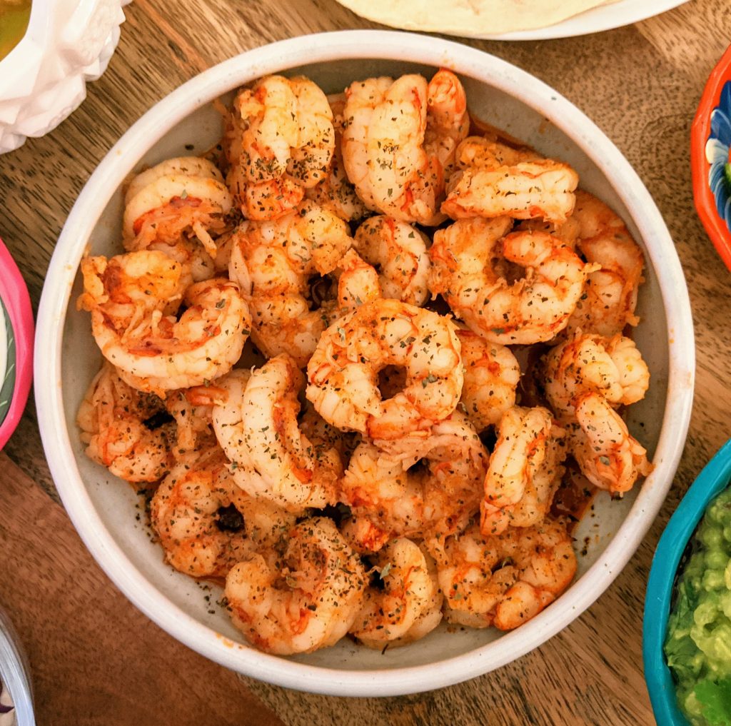 A plate of spicy lime shrimp garnished with dried oregano.