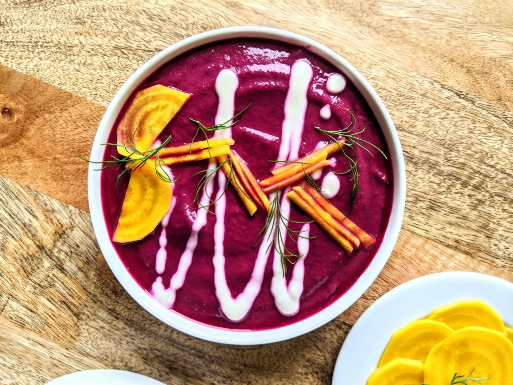 A bowl of Beetroot Gazpacho, garnished with Greek yogurt, pickled golden beets, and fresh dill.
