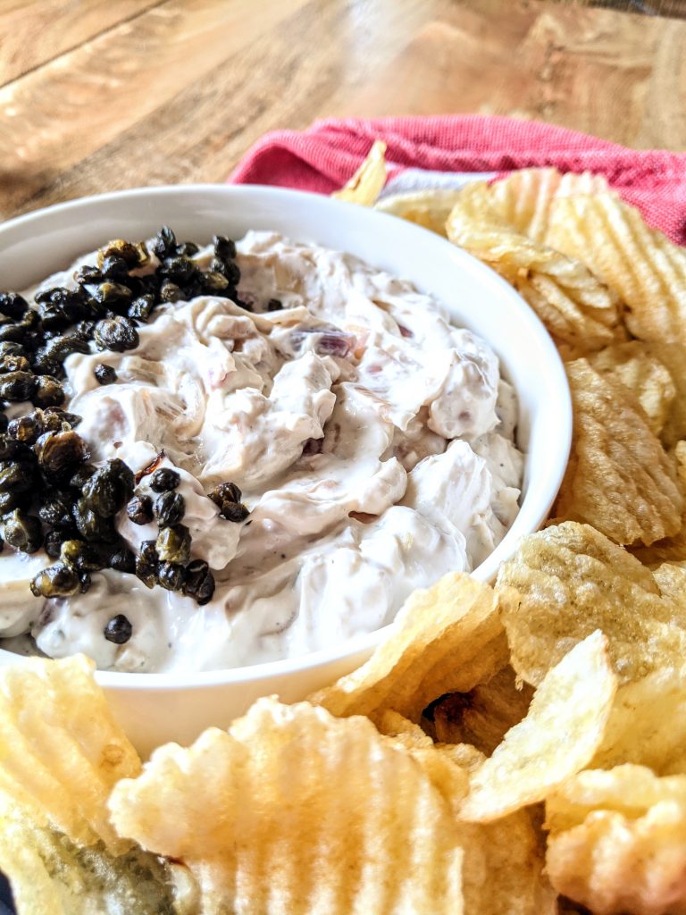 A close up of a thick Buttermilk and French Onion Dip with Fried Capers.
