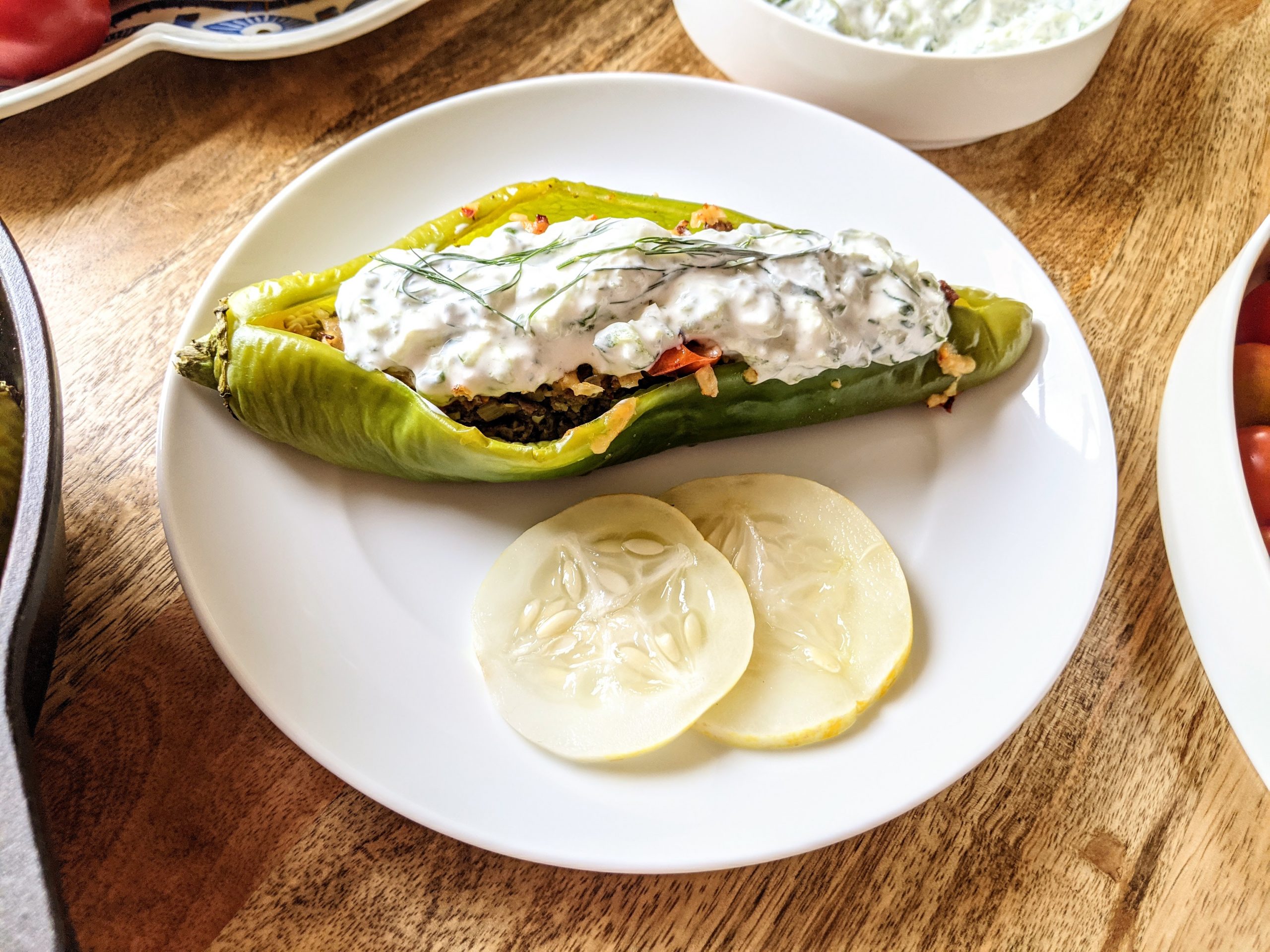 A Georgian inspired stuffed hatch chili pepper, served with yogurt sauce on top and homemade pickled lemon cucumbers.
