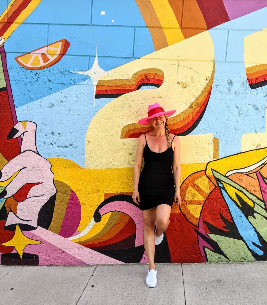 Standing in front of a vibrant mural next to San Francisco's Painted Ladies in Alamo Square.