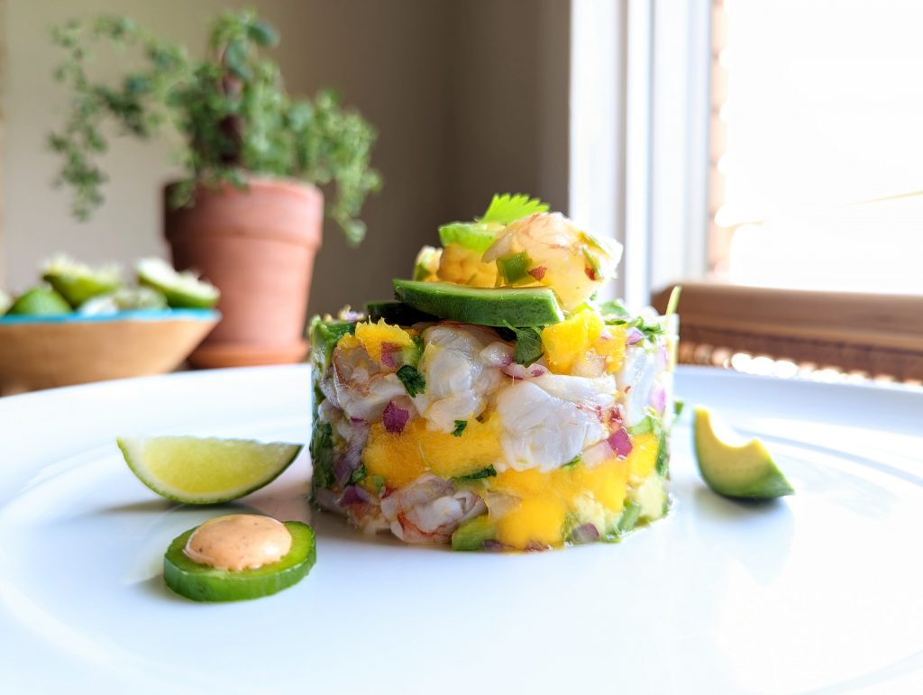 A table-side closeup of shrimp ceviche with mango and avocado.