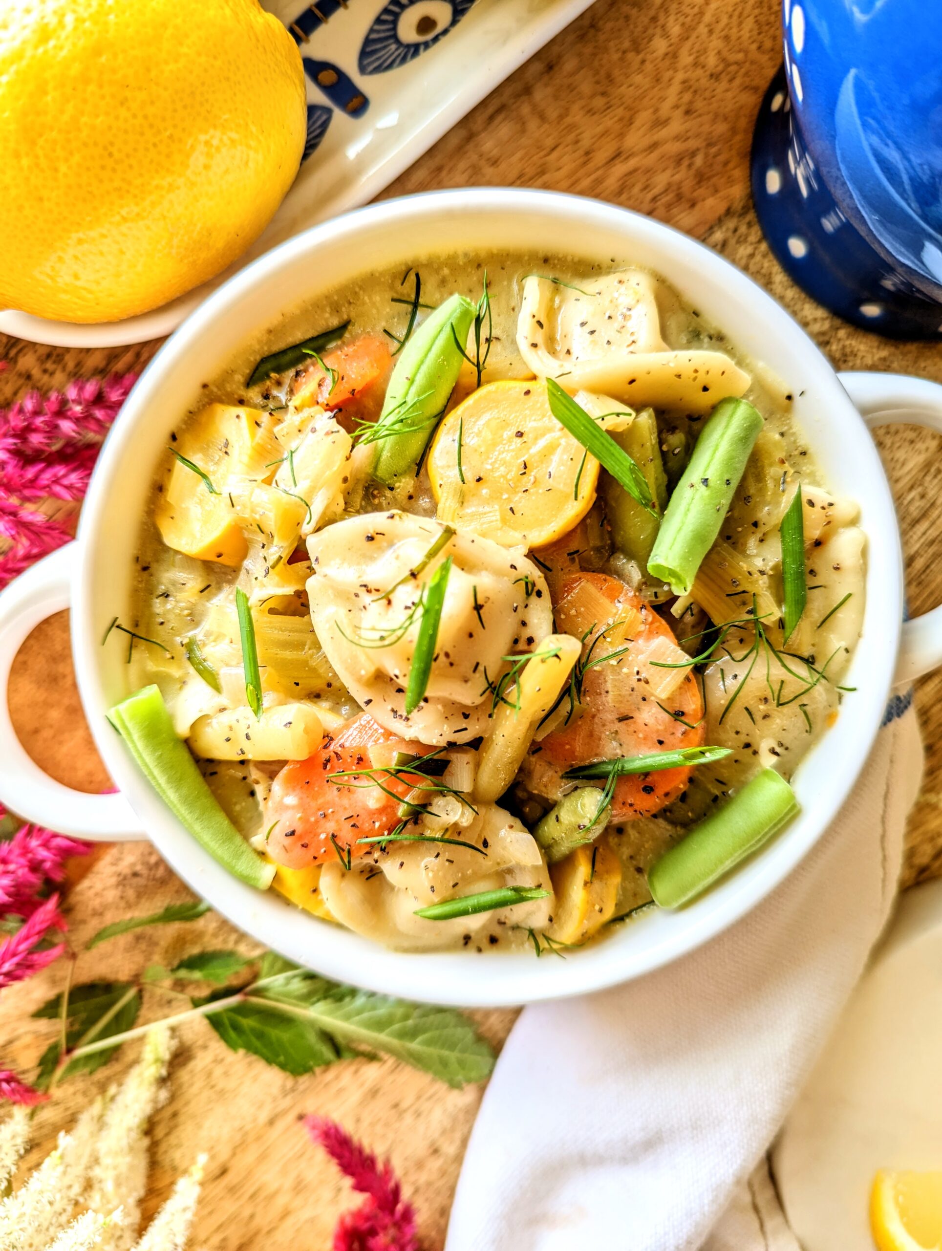 A bowl of colorful and hearty spring vegetable and tortellini soup.
