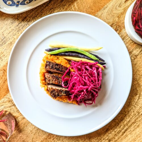 A colorful dinner topped with pickled red cabbage.